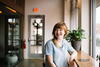 A strata manager smiling and sitting at a table, with her mobile phone placed on the table